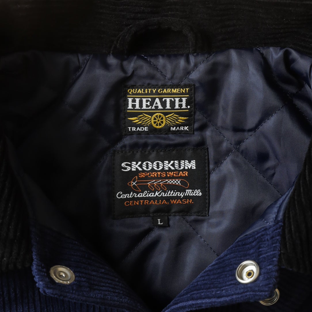 襟元のHEATHとSKOOKUMのタグ
